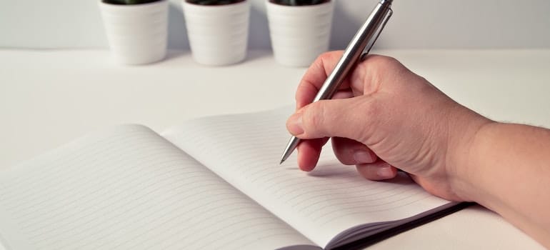 A person holds a silver retractable pen