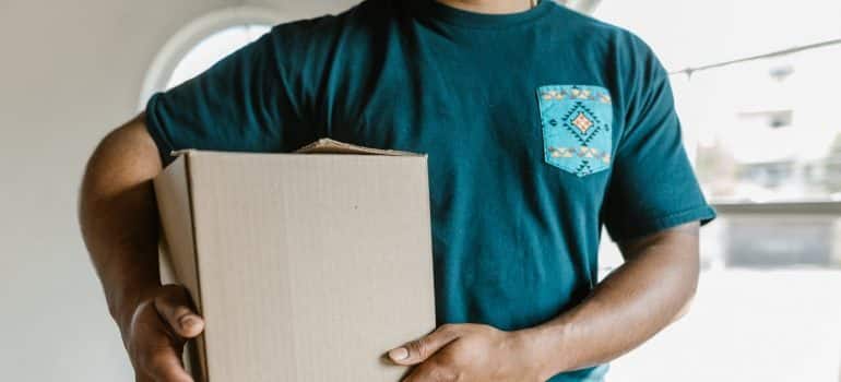 A movers holding a cardboard box