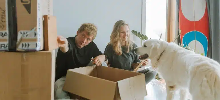 couple with dog unpacking after a household relocation