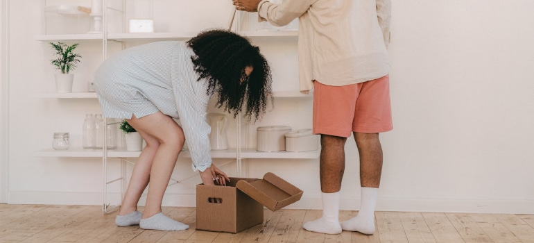 woman picking up decor from a box