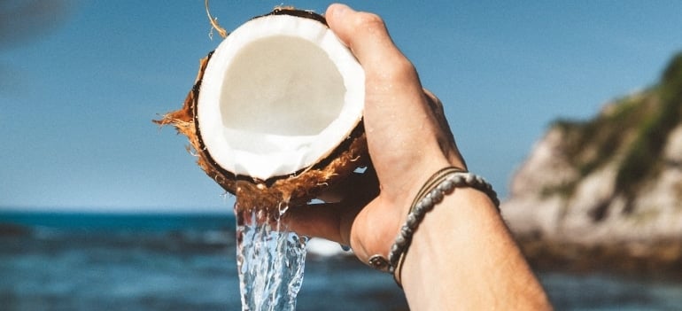 Picture of a hand pouring coconut water 
