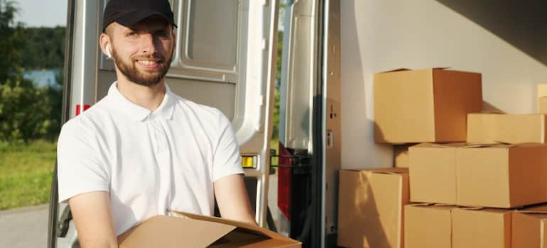 man with a cap holding a box