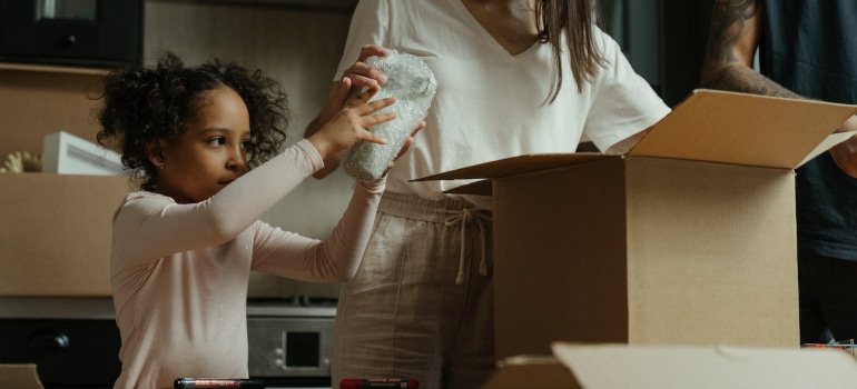 kid helping with unpacking after a household move