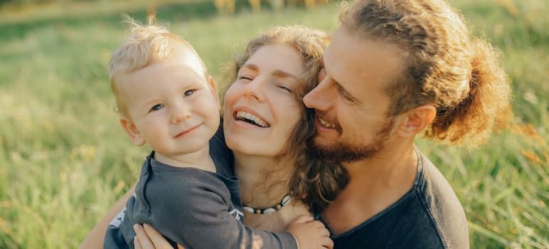 A man, woman and their kid smiling after relocating to Homestead as a family.