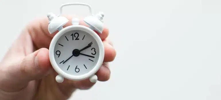 a person holding a small white clock