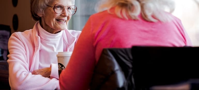 Photo of old woman sitting while talking with another woman