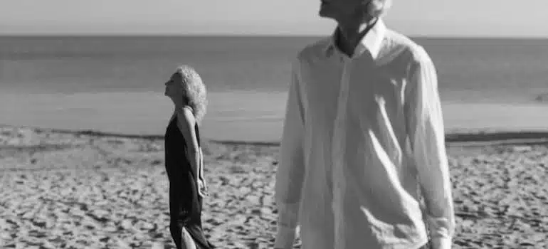 Grayscale photo of an old couple on the beach.