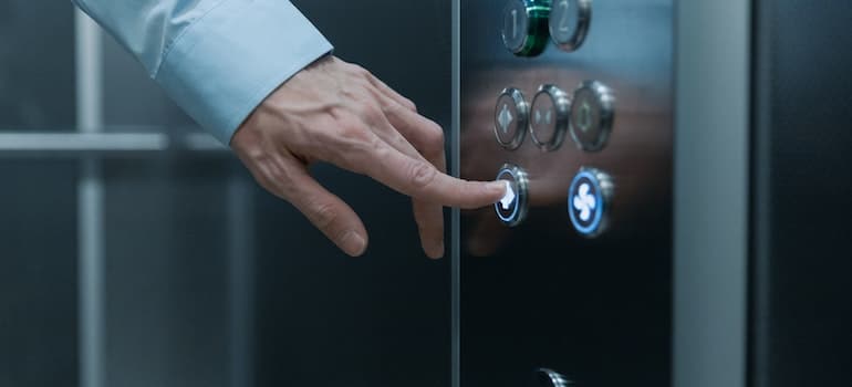 Mans hand pressing an elevator button