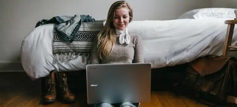 girl sitting on the floor looking at the computer
