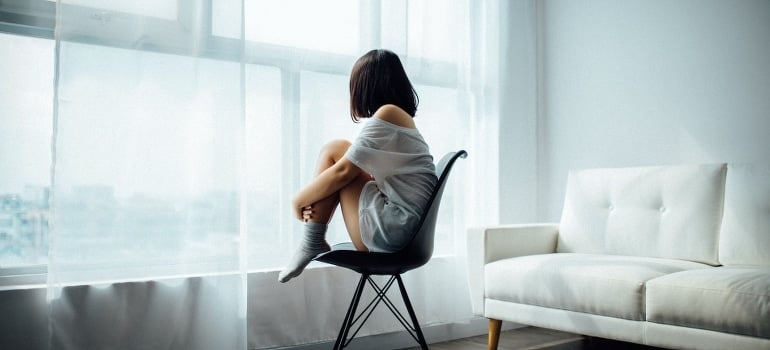 A girl sitting on the chair near the window