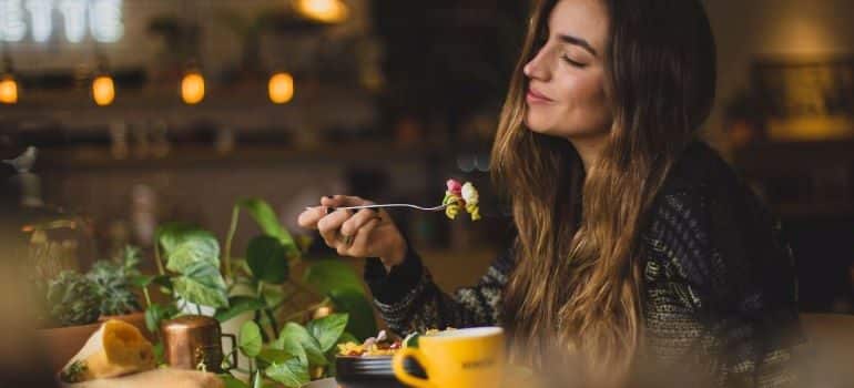 A woman enjoying food in one of the healthy restaurants in Miami Beach