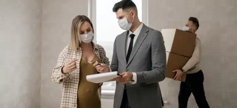 a couple with a real estate agent discussing about the price of home