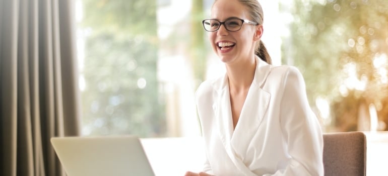 a woman laughing because she knows how to look for a new Miami apartment remotely