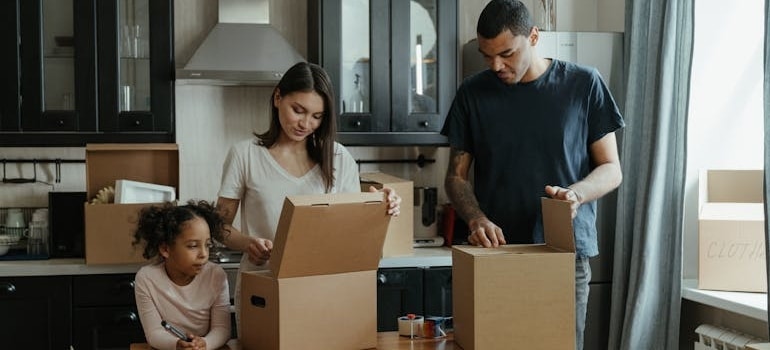 A family learning to pack and unpack kitchen appliances.