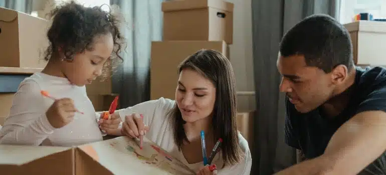 A family drawing on a moving box after moving house with a baby