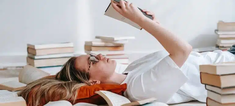 Young women reading a book on the floor about essentials for a corporate relocation in Hollywood