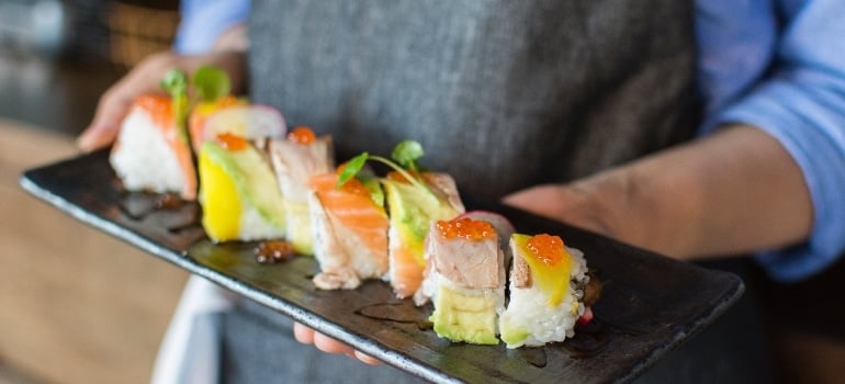 Man bringing Japanese food on a plate