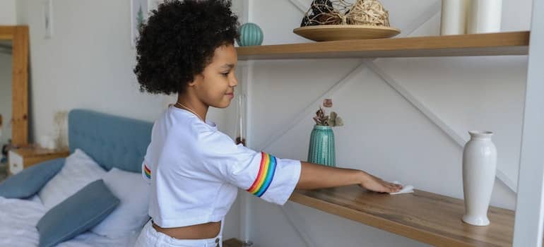 a girl cleaning a shelf