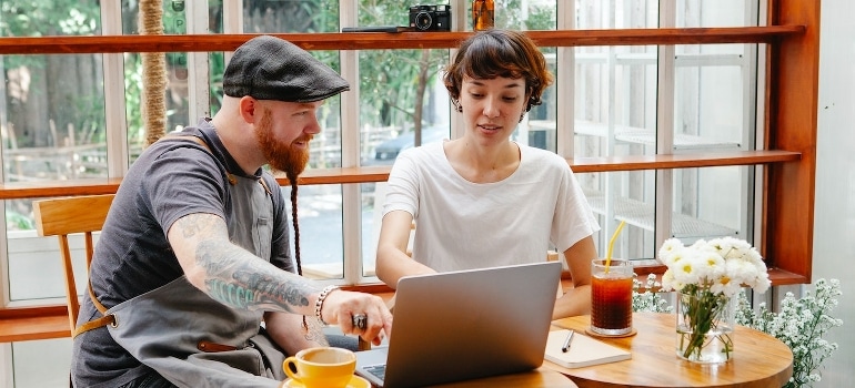 Friends use a laptop to find out if cheap movers can be trusted