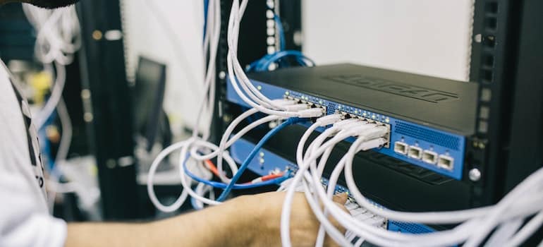 Electronics Engineer Fixing Cables on Server.