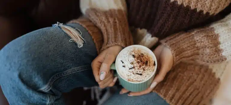 person drinking coffee after unpacking and settling into your new home