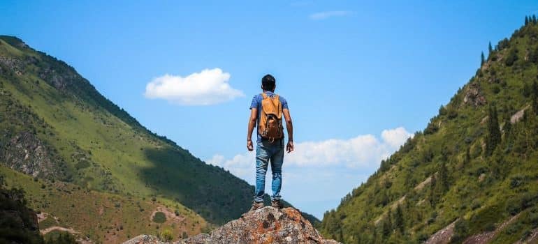 a man standing on the peak looking at the horizon