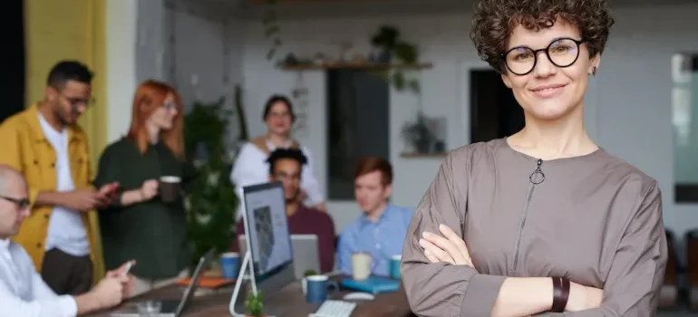 A woman with glasses smiling and thinking about career prospects after moving to Miami