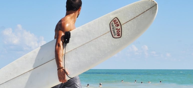A man carrying a surf board