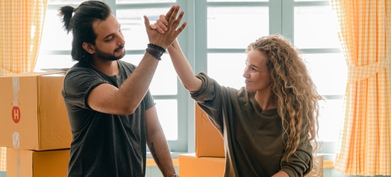 A couple high five after using white glove services when moving your Homestead home