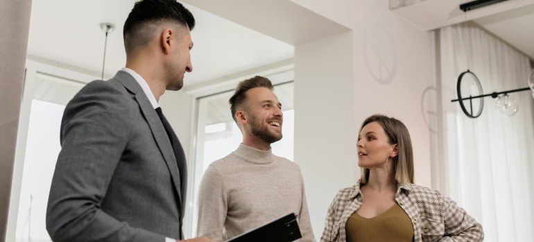 A real estate agent talking with a couple about trends in Miami luxury real estate market 