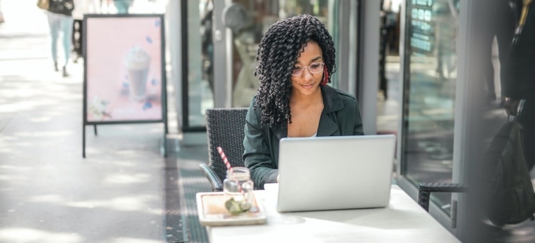 A woman searching the internet about finding office space in Miami before the move