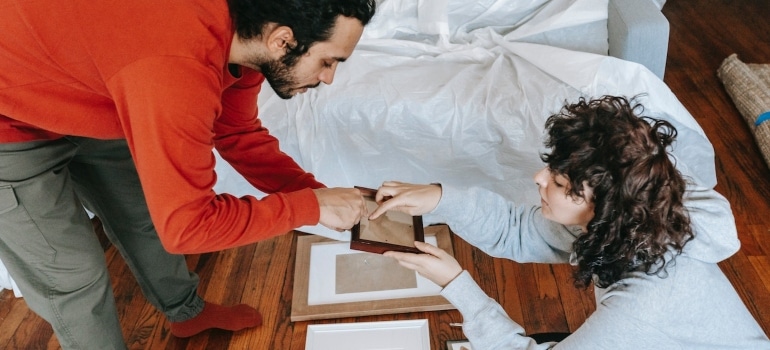 A couple preparing for packing paintings and canvases