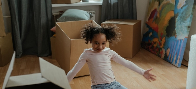 a happy girl surrounded by boxes and a picture