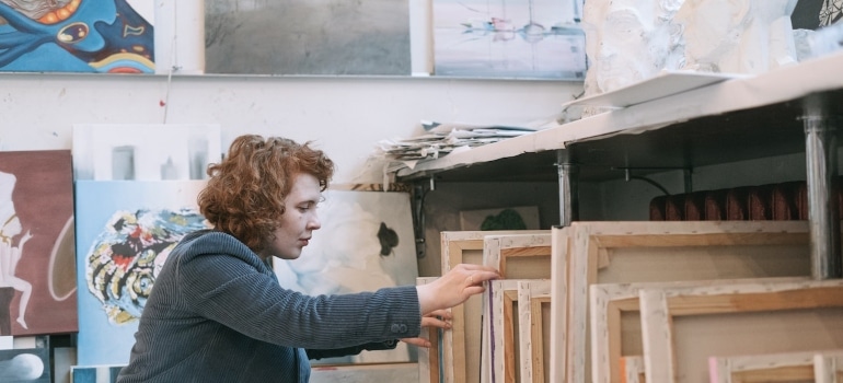 A woman looking through canvases