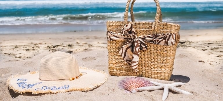 a hat, a bag, and a starfish on a beach