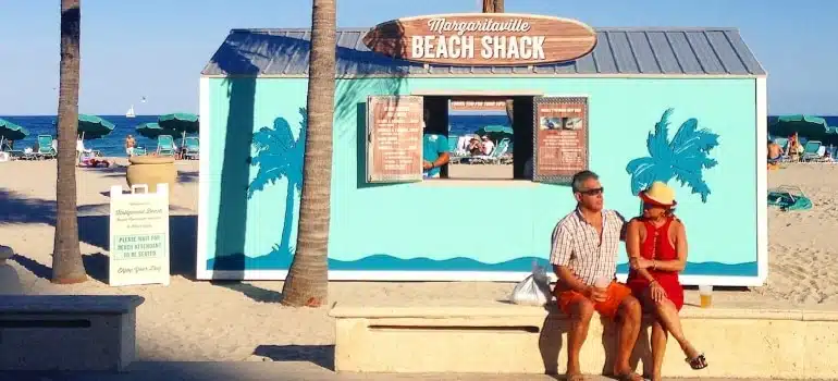 Two people sitting at a beach enjoying Florida activities