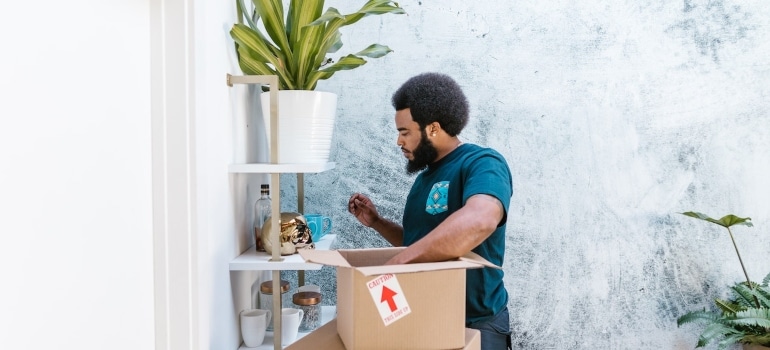 A mover packing a box for a last-minute art move