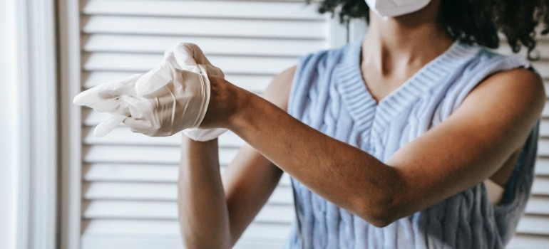 A woman putting on white gloves as an example of using white glove services when moving your Homestead home