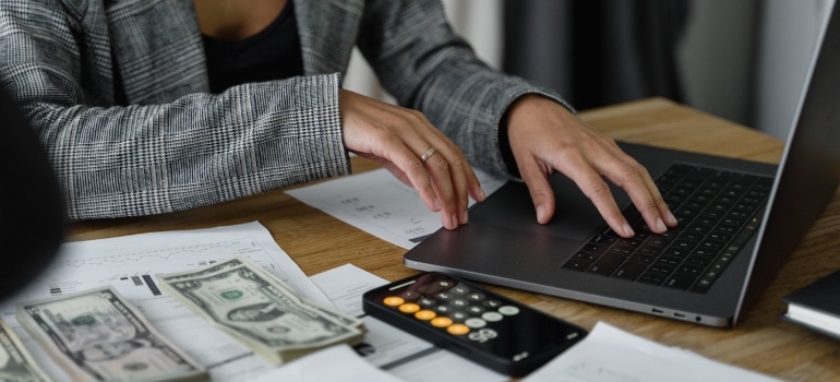 A woman calculating the costs of Coconut Grove vs. Coral Gables