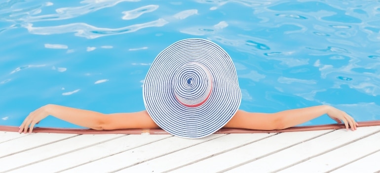 a woman with a hat in a swimming pool