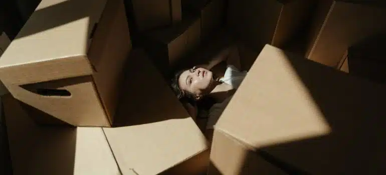 a woman under bunch of boxes
