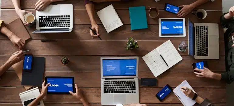 People with various gadgets sit around a table in one of the best high-tech cities in Florida to move to