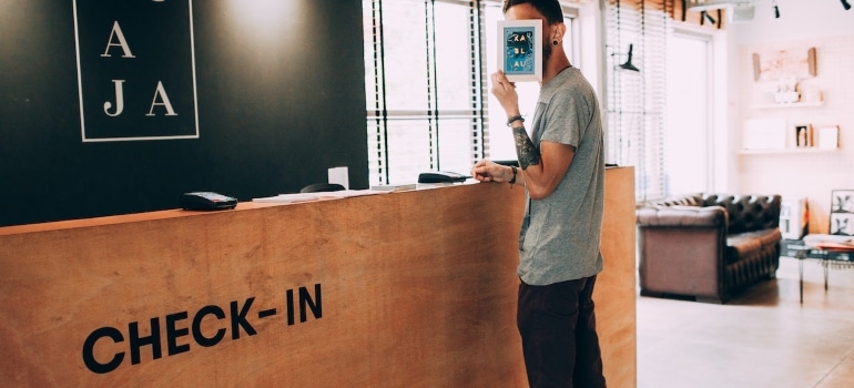 a man at the check in counter before moving a hotel in Miami