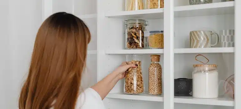 A woman in her pantry shows how to declutter your home storage with ease