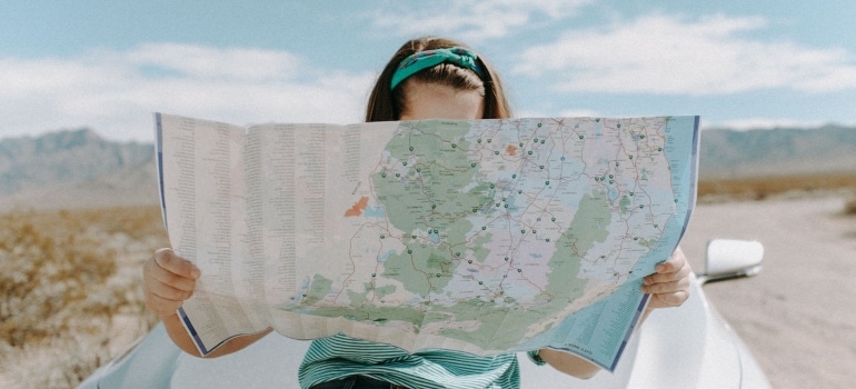 a woman holding a map before exploring things to do in Plantation FL