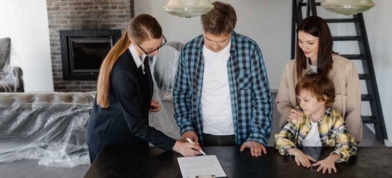 a family with a real estate agent signing in a contract before moving from Plantation to Pinecrest