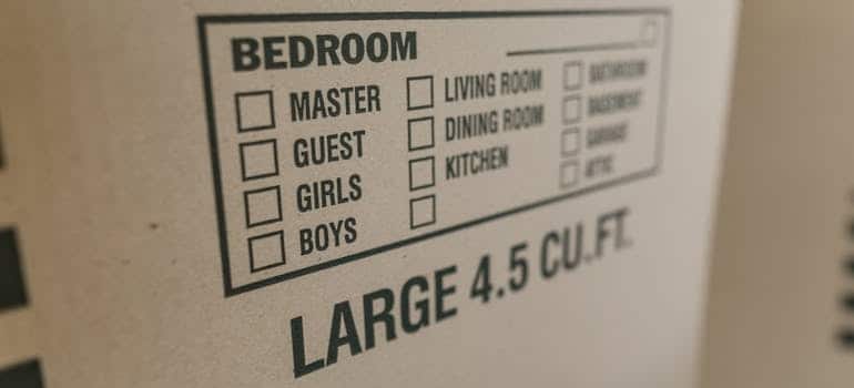 A brown cardboard box with detailed label for decluttering