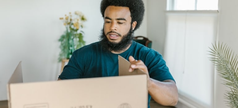 a mover making cardboard boxes to help you declutter your home with ease 