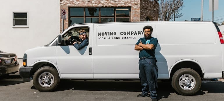 movers next to a van thinking about moving antique furniture to Coral Springs