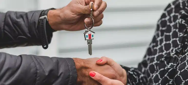 A man giving keys to a woman